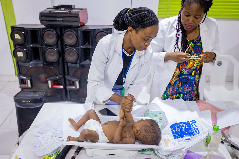 Nurses Mopelola Oladapo and Banjo Bukola conduct medical checkup for babies at the Nutritious Meal Plan Intervention Program for Vulnerable Mothers & Children (NUMEPLAN) at the Lagos Food Bank Initiative facility. (Photo: The Global FoodBanking Network, Julius Ogundiran)