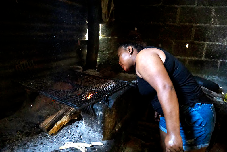 Lesly Lopez stokes a fire that will be used to make soup using the food provided by Desarrollo en Movimiento. (Photo: The Global FoodBanking Network/Tomas Ayuso)